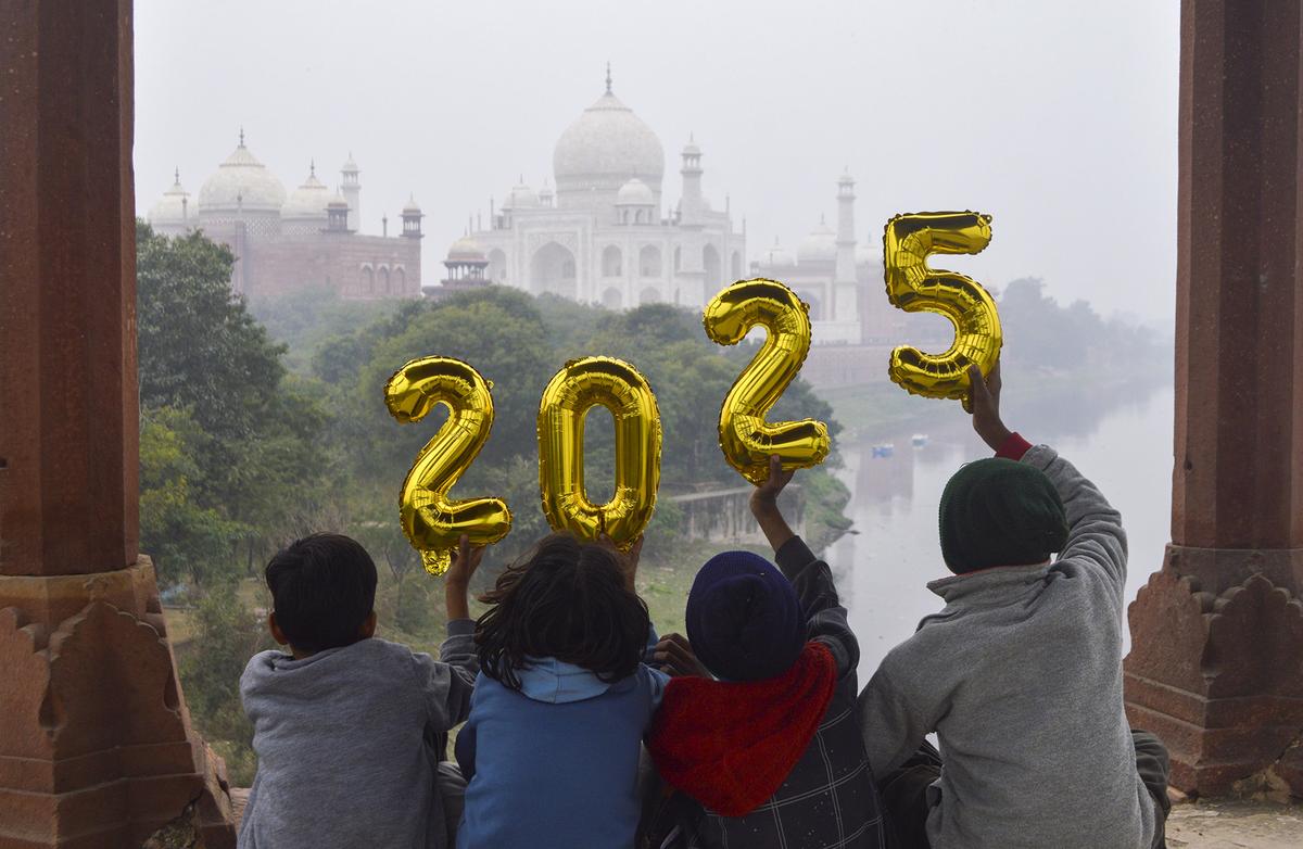 Agra: Children pose on the eve of the new year 2025, near the Taj Mahal in Agra, Uttar Pradesh