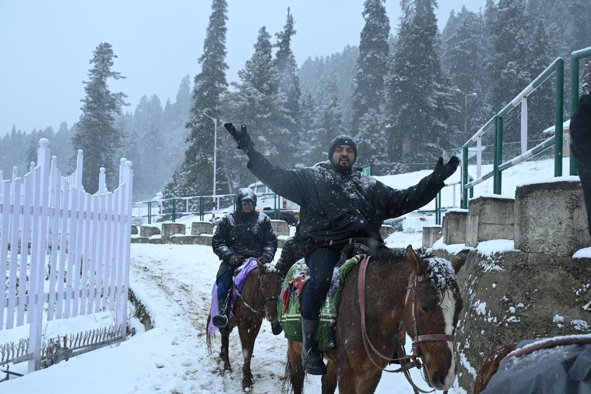Los turistas disfrutan de la estación de esquí cubierta de nieve en Gulmarg durante una nevada fresca en la famosa estación de esquí de Gulmarg, a 55 km de Srinagar, el 21 de diciembre de 2025. 