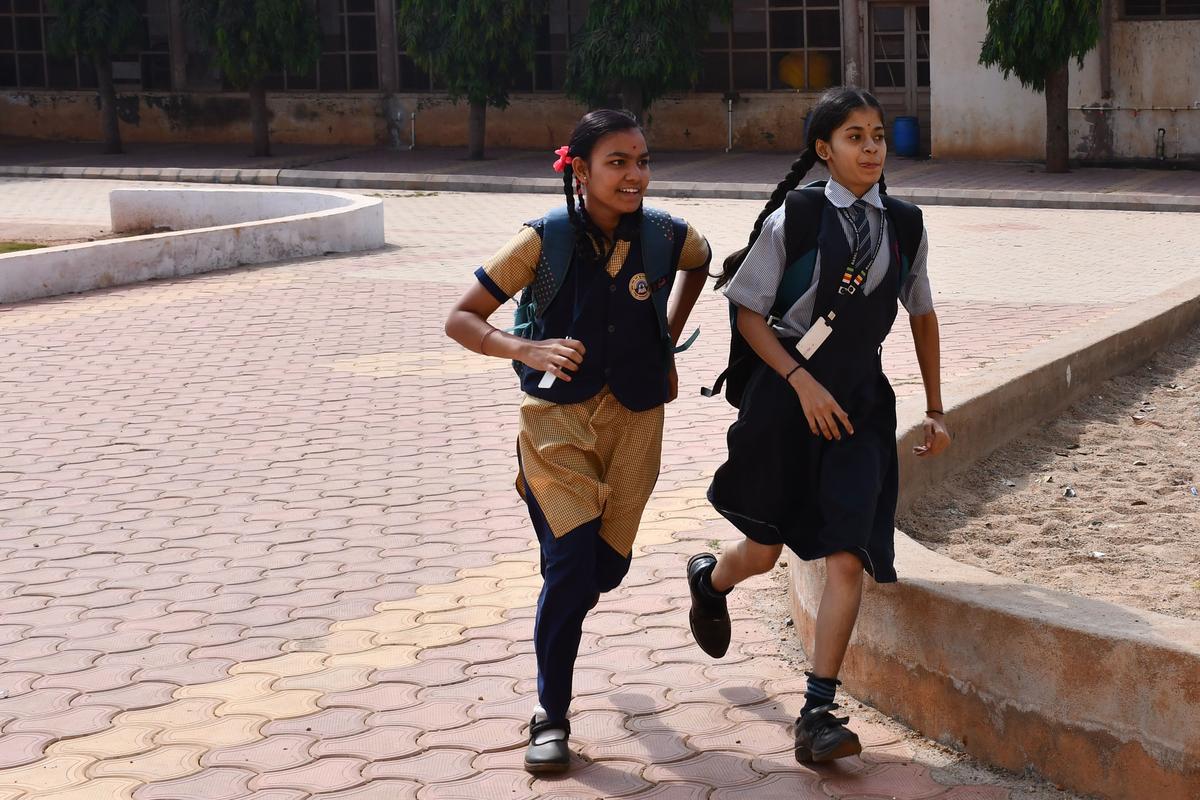 Students rushing to an SSLC examination centre in Hubballi on Friday. 