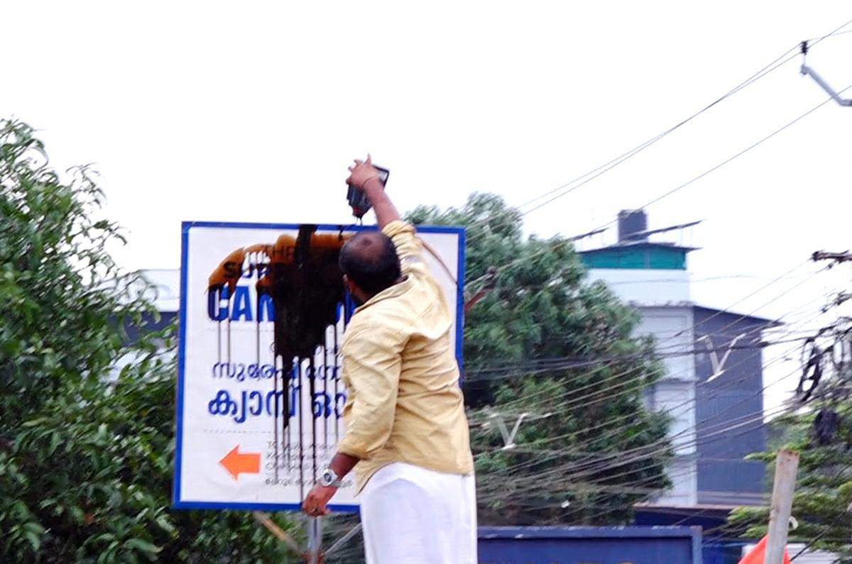 A CPI(M) worker pouring block oil on the signboard of Union Minister Suresh Gopi’s office in Thrissur on Tuesday. 