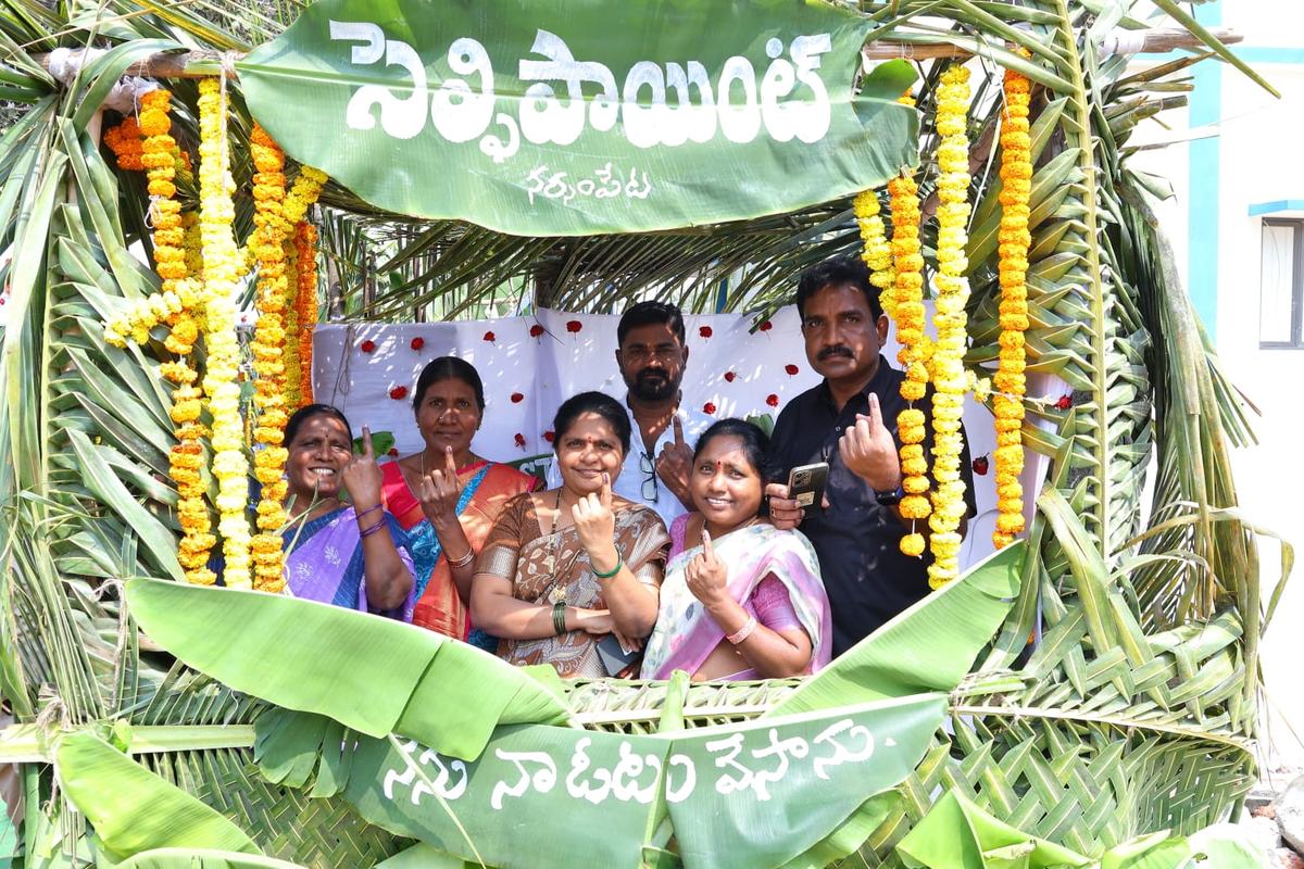 Voters pose for a photo at a selfie point set up at a Green Polling Station in Narsampet in Warangal district.