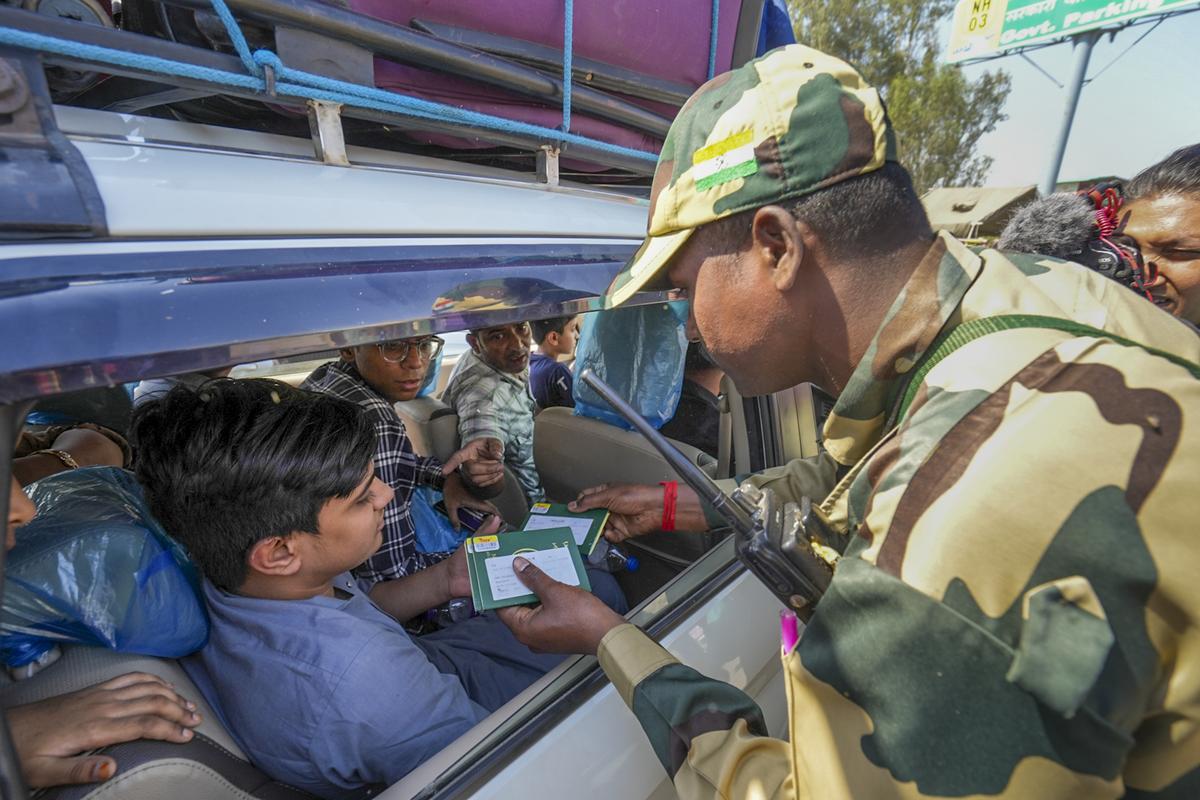 A security personnel checks the passports of Pakistani nationals as they arrive at the Attari-Wagah border to move to their country, near Amritsar on April 27, 2025. A security personnel checks the passports of Pakistani nationals as they arrive at the Attari-Wagah border to move to their country, near Amritsar on April 27, 2025.