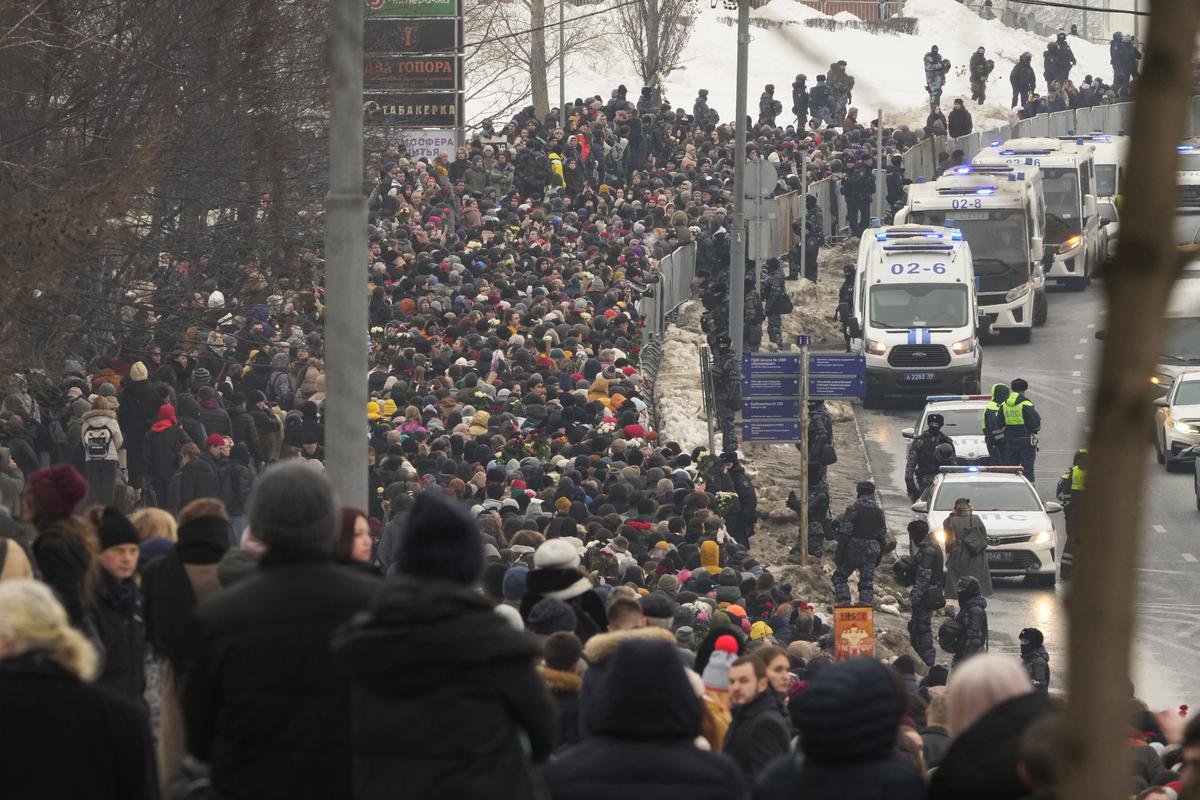 Police, right, observe as people walk towards the Borisovskoye Cemetery for the funeral ceremony of Russian opposition leader Alexei Navalny, in Moscow, Russia, Friday, March 1, 2024. Under a heavy police presence, thousands of people bade farewell Friday to Alexei Navalny at his funeral in Moscow after his still-unexplained death two weeks ago in an Arctic penal colony. 