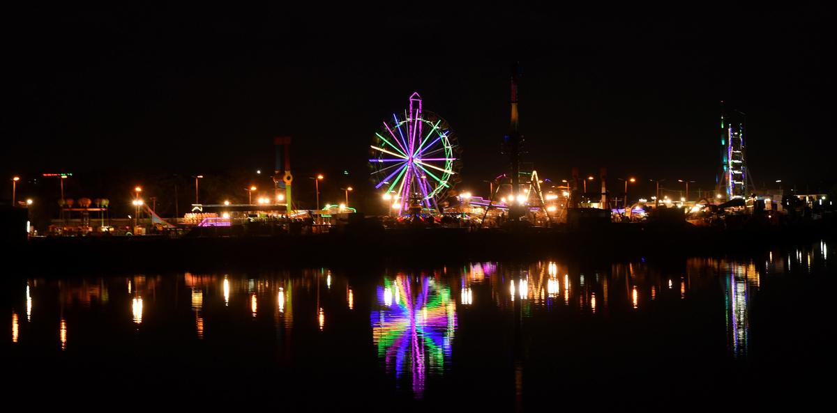 O redemoinho de uma roda gigante forma padrões coloridos e reflexos no rio Cooum durante a exposição da Feira de Turismo e Comércio da Índia no Island Grounds em Chennai, em 28 de janeiro de 2019