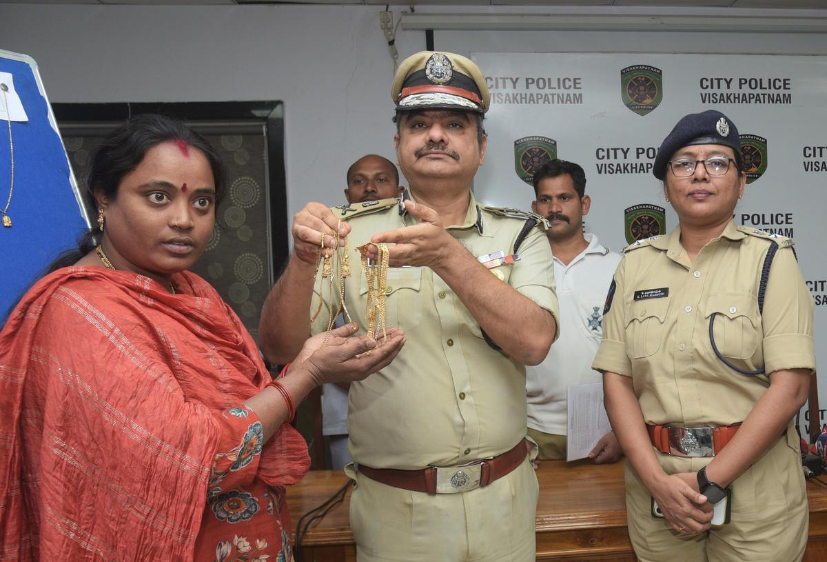 O comissário de polícia Shankabratha Bagchi entrega joias de ouro recuperadas a uma mulher durante o Monthly Crime Mela em Visakhapatnam no sábado.