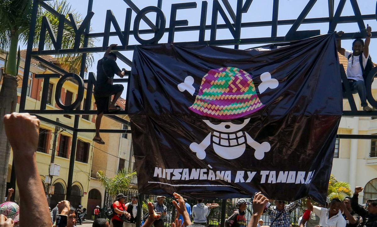 Protesters hang a banner featuring a Malagasy version of the logo of the popular Japanese manga One Piece, a symbol adopted by Gen Z protest movements worldwide, during a nationwide youth-led demonstration over frequent power outages and water shortages, in front of the City Hall in Antananarivo, Madagascar, October 13, 2025. 