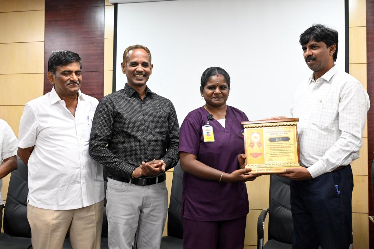 District Collector S. Kandasamy (right) felicitating a staff  at the Erode Government Hospital on Wednesday.  
