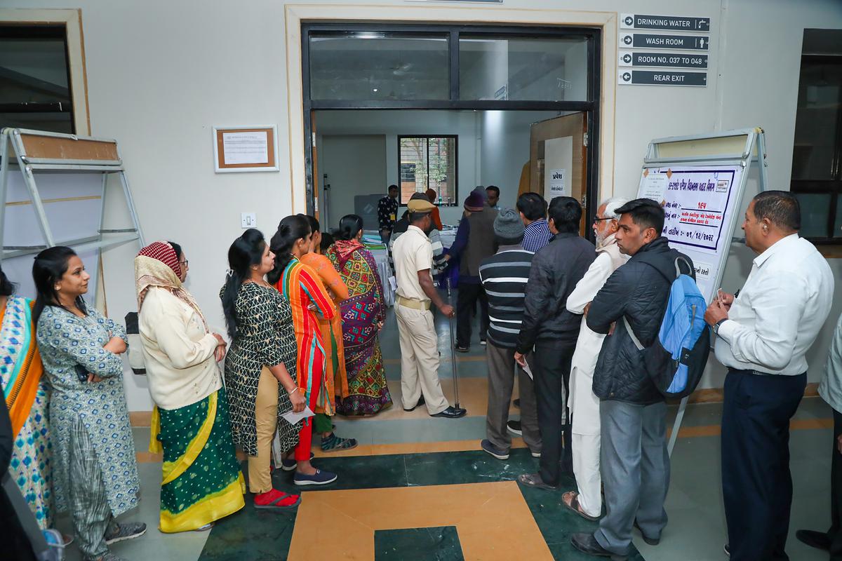 People wait in queues to cast their votes during the first phase of Gujarat Assembly elections, in Rajkot on December 1, 2022.