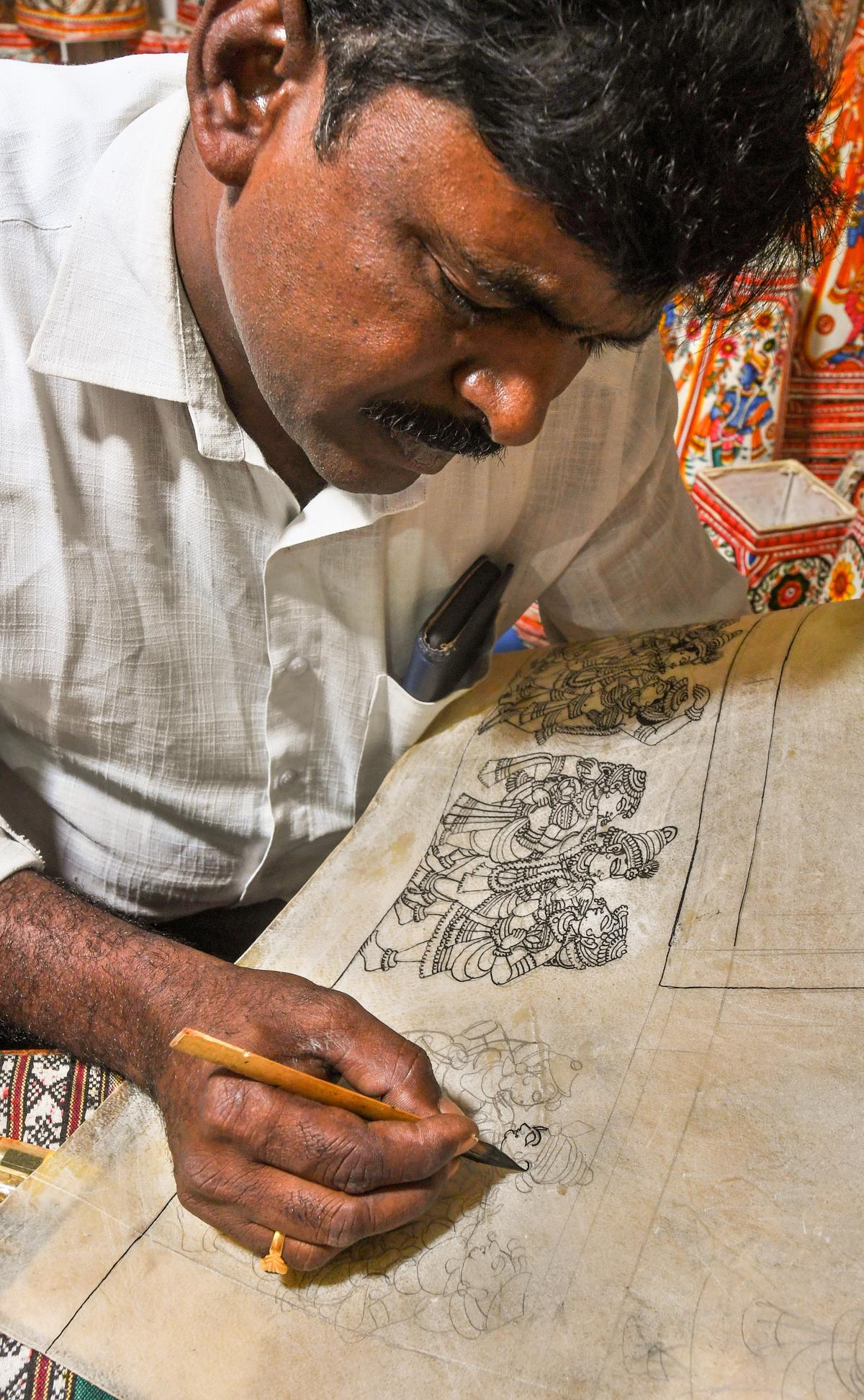 A Tholu Bommalata craftsman making a design with bamboo nib and black ink on goat skin leather at DWCRA Bazaar at Andhra University Engineering Grounds in Visakhapatnam 