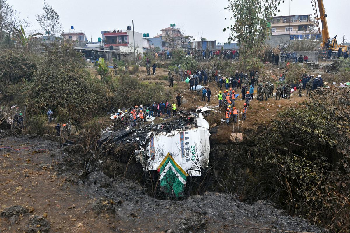 Rescuers inspect the wreckage at the crash site on January 16.