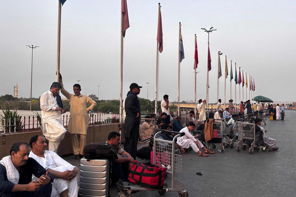 Passengers wait outside at Jinnah International airport after all domestic and international flights were cancelled in Karachi on May 7, 2025. Passengers wait outside at Jinnah International airport after all domestic and international flights were cancelled in Karachi on May 7, 2025.