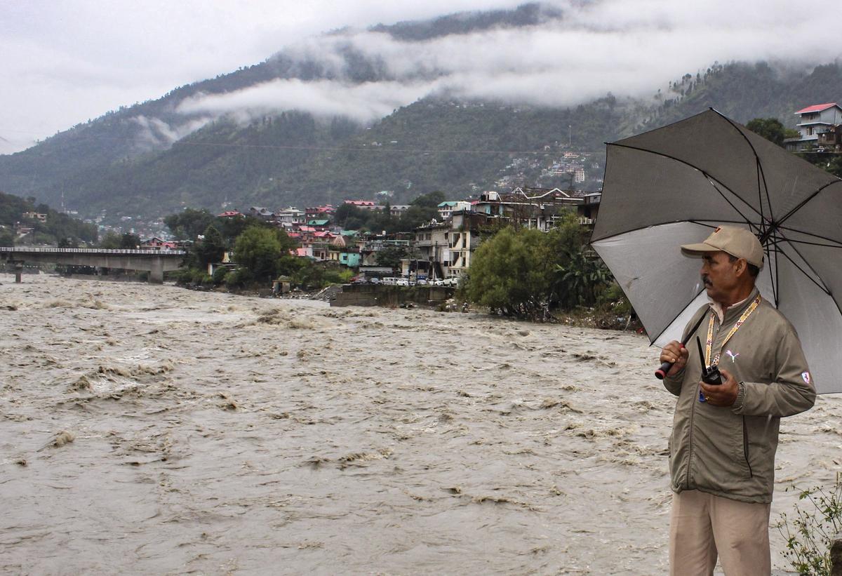 A security official keeps a watch as the Beas river flows in spate following incessant rains, in Kullu district A security official keeps a watch as the Beas river flows in spate following incessant rains, in Kullu district