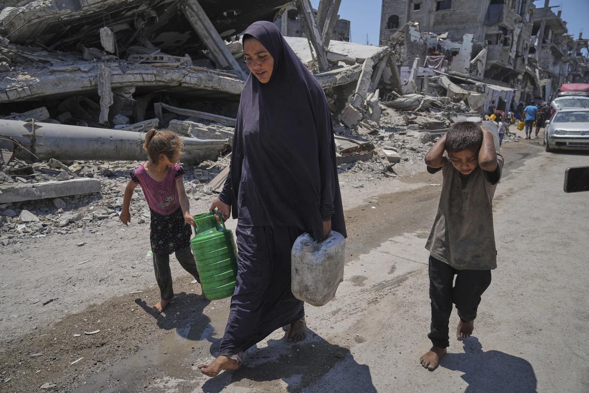 Abeer Sobh and her children carry water in plastic jerrycans after collecting it from a water truck in Gaza City, Thursday, July 24, 2025. Abeer Sobh and her children carry water in plastic jerrycans after collecting it from a water truck in Gaza City, Thursday, July 24, 2025.