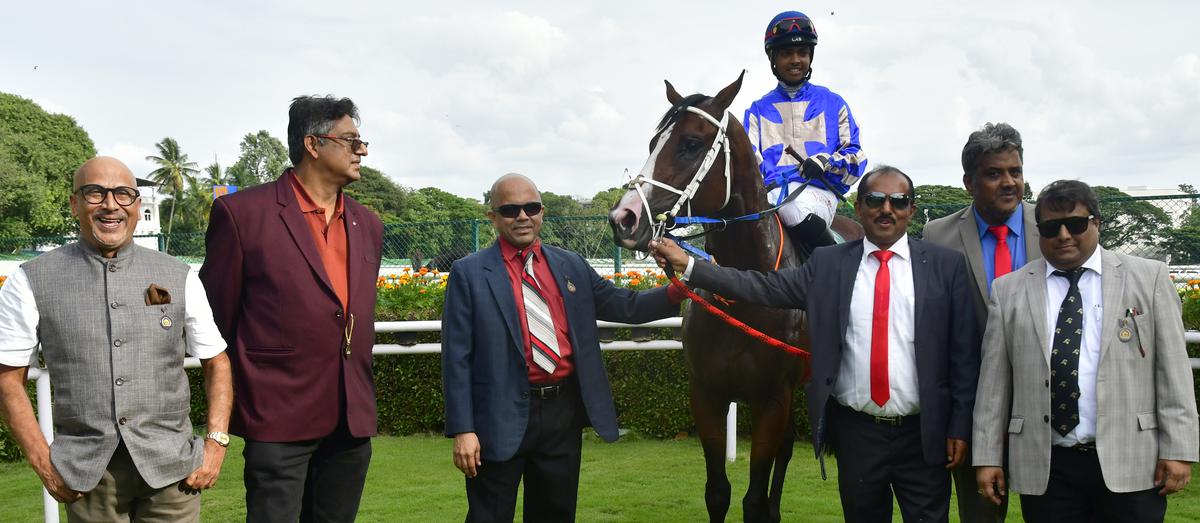 Owners D. Sanjeev Basapa, M.N. Nambiar, K. Balamukunda Das, K. Kamesh and N. Swaroop Kumar, along with trainer Prasanna Kumar, second from left, leading in Knotty Charmer (G. Vivek up) after the winning run in the Colts Championship Stakes at the Bangalore Turf Club in Bengaluru on June 25, 2023. 