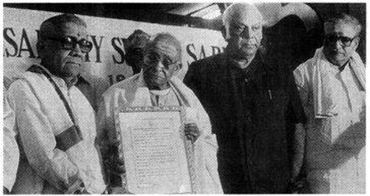 Sri Semmangudi R. Srinivasa Iyer presenting the title of'Sangeetha Kala Sarathy' to Sri Madurai N. Krishnan (extreme left) at a (function organised by Sri Parthasarathi Swami Sabha) in 1998. M.A. M. Ramaswami, industrialist and Justice K. S. Bakthavatsalam look on. Sri Semmangudi R. Srinivasa Iyer presenting the title of'Sangeetha Kala Sarathy' to Sri Madurai N. Krishnan (extreme left) at a (function organised by Sri Parthasarathi Swami Sabha) in 1998. M.A. M. Ramaswami, industrialist and Justice K. S. Bakthavatsalam look on.