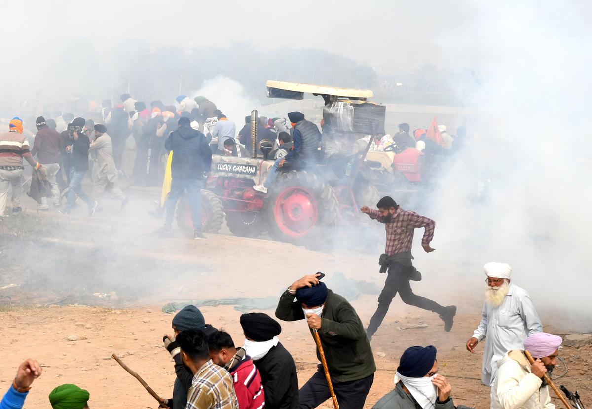 Farmers ran as police personnel fired tear gas canisters on them as they were advancing towards Delhi to seek enactment of a law on minimum support price at Shambhu Barrier in Punjab on February 13, 2024. 