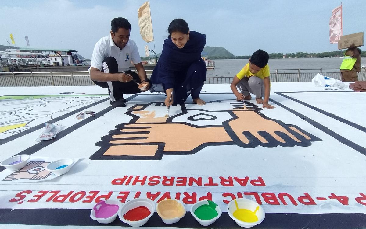 NTR District Collector G. Lakshmisha and his family participating in the floor painting competition at Haritha Berm Park in Vijayawada on Sunday. NTR District Collector G. Lakshmisha and his family participating in the floor painting competition at Haritha Berm Park in Vijayawada on Sunday.