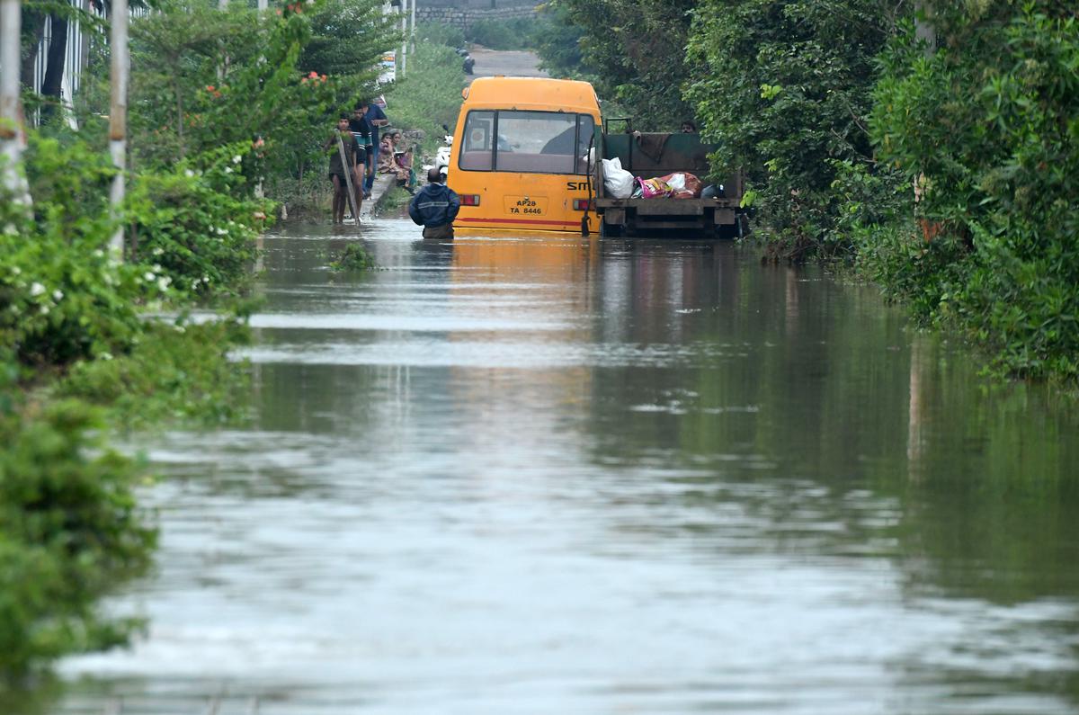 A private bus stuck in the water on the main road in Dundigal village on Tuesday, following heavy rain.