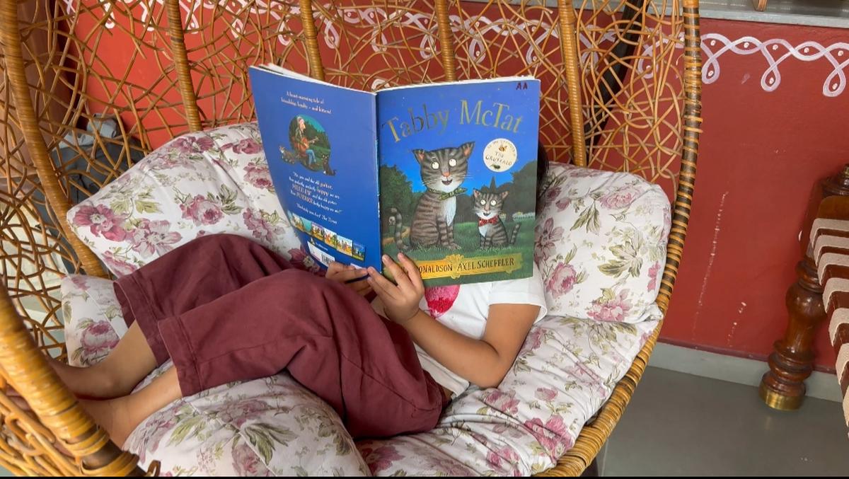 Un bambino legge un libro in biblioteca 