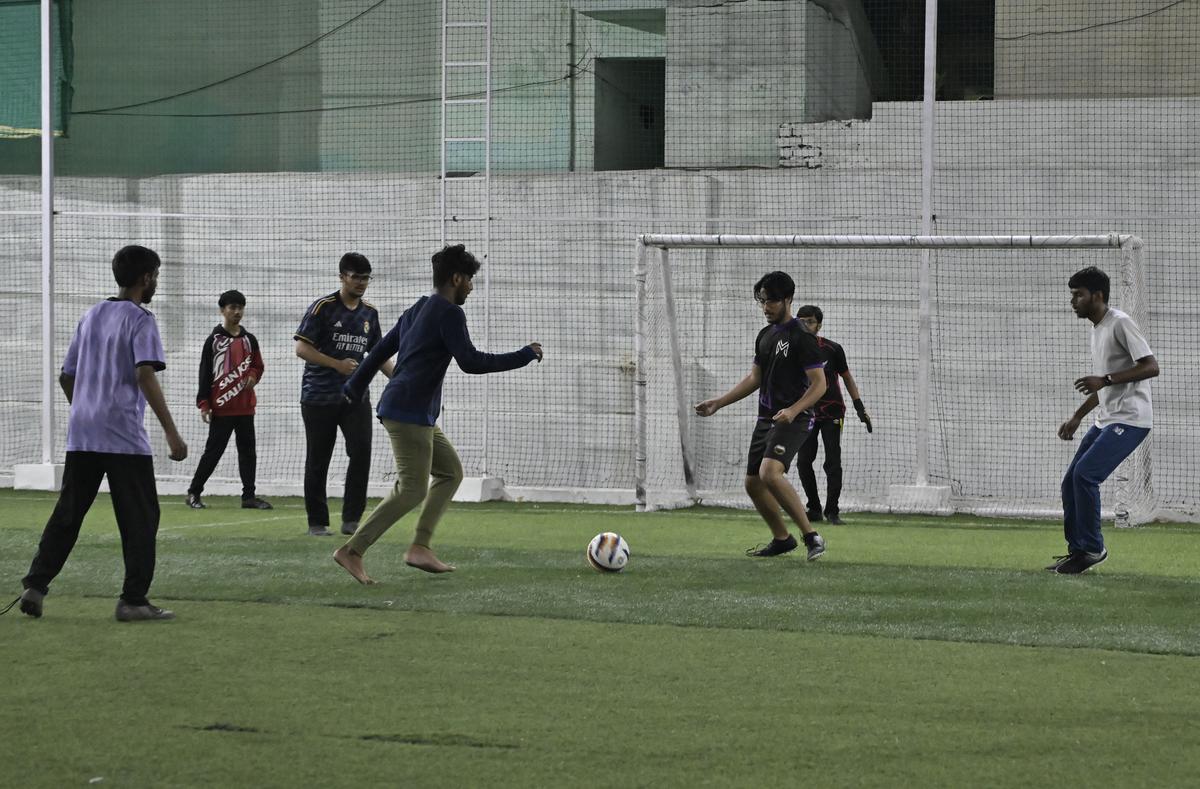 People play a late-night football match under floodlights at Game On turf in Hyderabad. File 