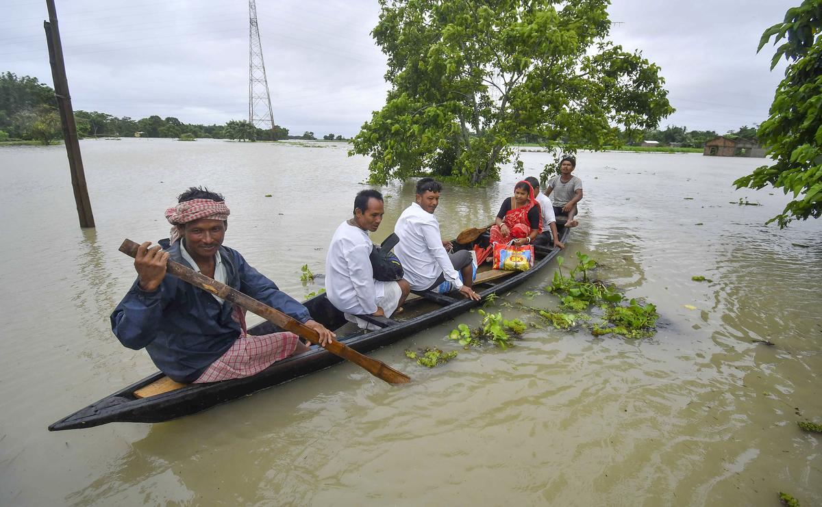 People use a boat to cross flood waters following heavy rainfall, in Nagaon district on July 1, 2024. 