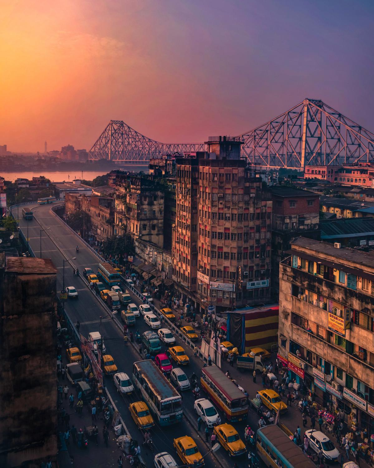 Kolkata at sundown with the Howrah Bridge in the background.