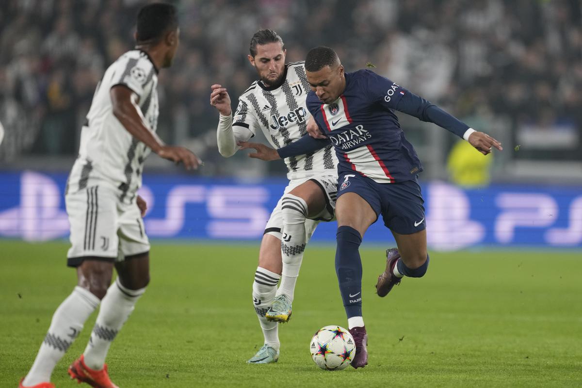 PSG’s Kylian Mbappe, right, fights for the ball with Juventus’ Adrien Rabiot during the Champions League group H soccer match between Juventus and Paris Saint Germain at the Allianz stadium in Turin, Italy