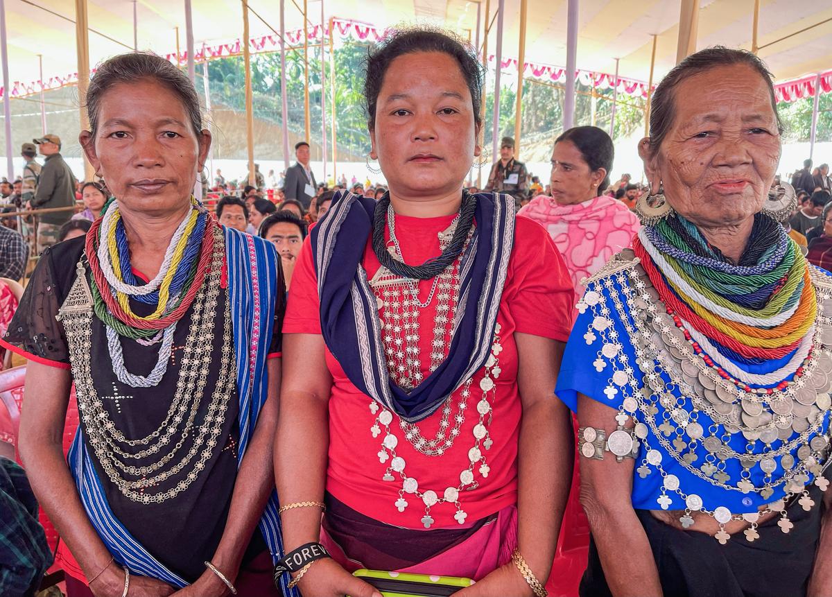 Bru tribal community members pose for a picture wearing traditional ornaments during the Union Home Minister Amit Shah public meeting, in Dhalai on December 22, 2024.