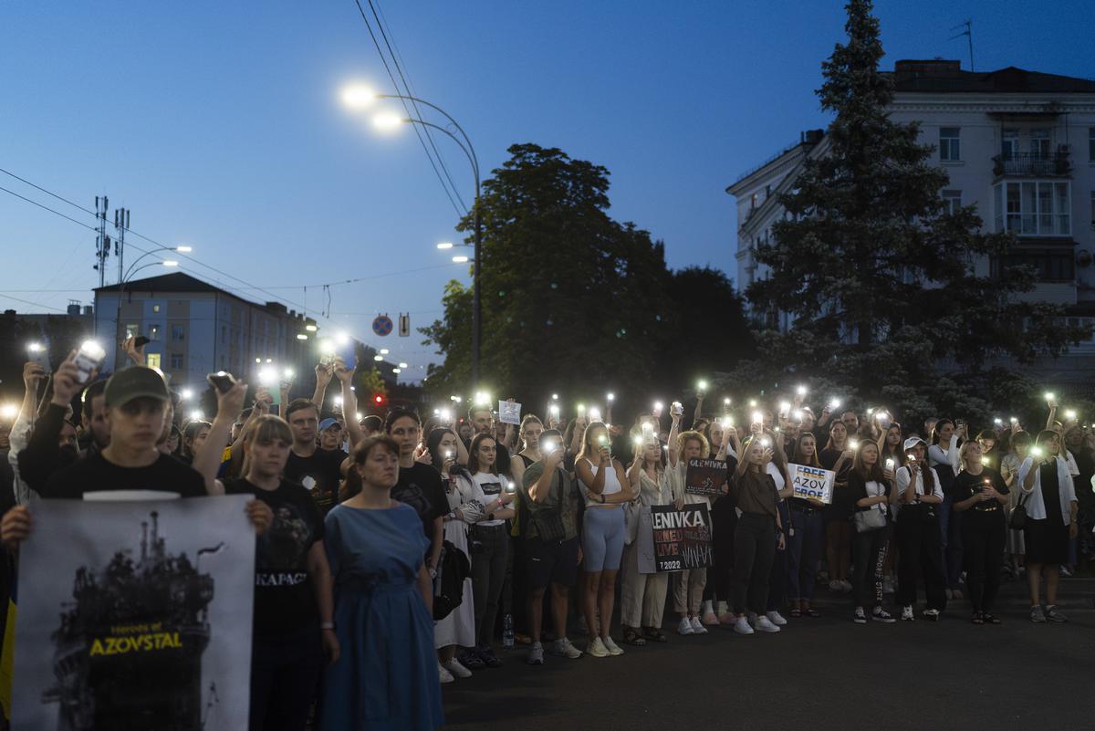 People light up their smartphones during a gathering outside the Russian Embassy in Kyiv, Ukraine.