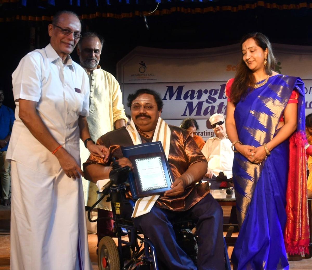 Cleveland Sundaram presents the Lifetime Achievement Award to mridangam exponent Erode Nagaraj at the Marghazhi Matram program in Chennai on Friday. 