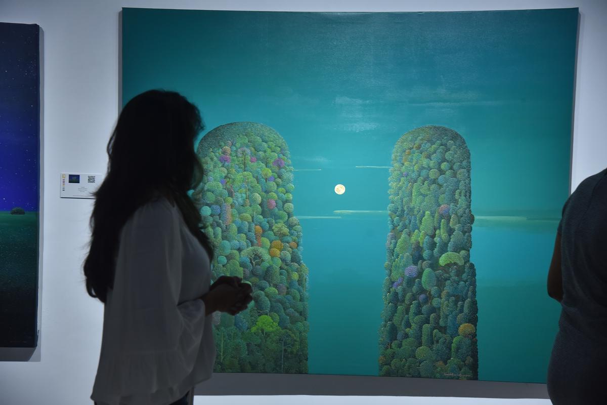 A visitor looks at the work by Suresh Kamballur