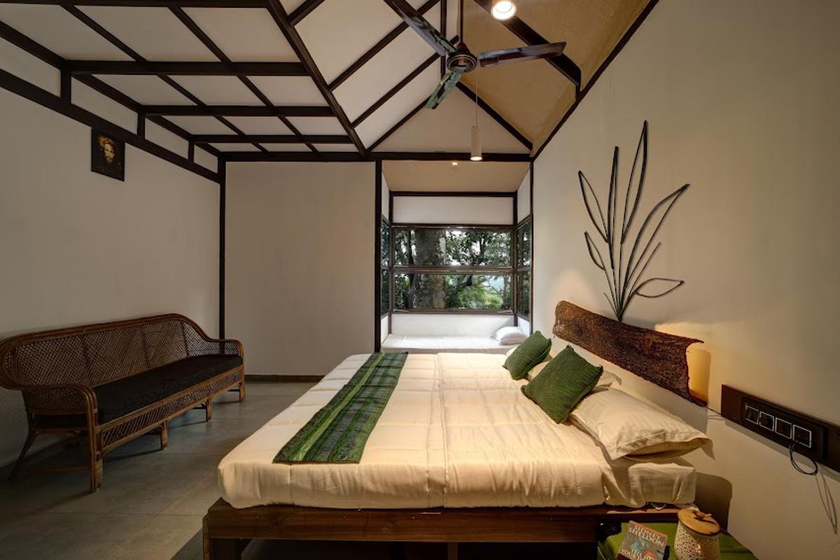 View of the cot in the bedroom made with wood sourced from the site, and the inner lay of the roof