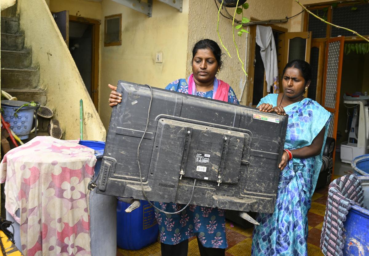 Flood victim L. Swaroopa (left) from GR Colony in Kamareddy shows the damage to her TV set after flash floods swept through the area following heavy rainfall. Flood victim L. Swaroopa (left) from GR Colony in Kamareddy shows the damage to her TV set after flash floods swept through the area following heavy rainfall.