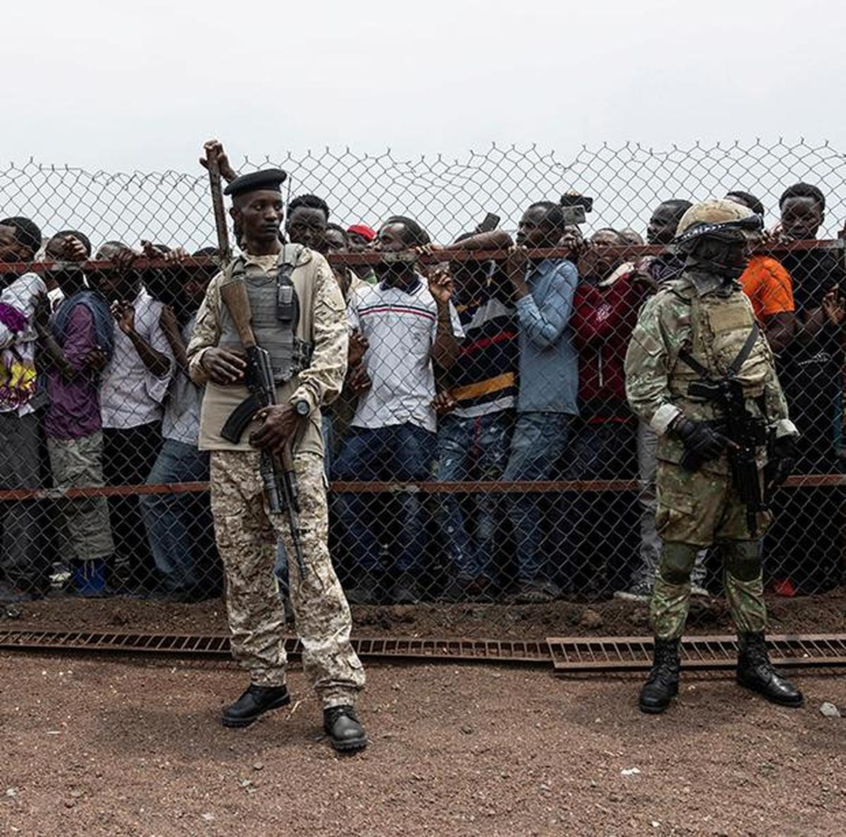 M23 rebels stand guard near civilians during a meeting organised by the M23 at the Stade de l'Unite, after the town of Goma was taken by the M23 rebels, in Goma, Democratic Republic of Congo, on February 6, 2025. 