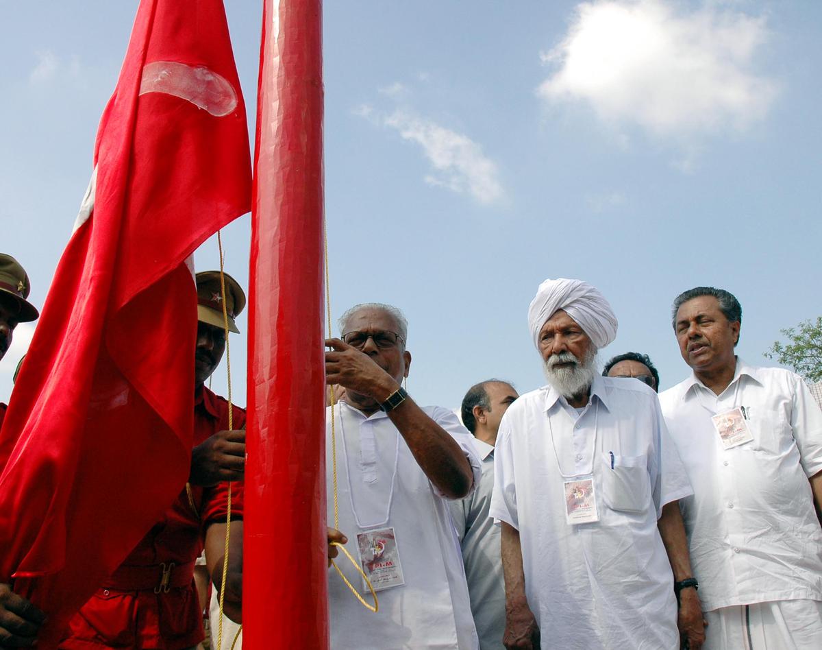 V.S. Achuthanandan hoisting the flag for the delegates conference at the CPI(M) State conference at Malappuram in 2005. Looking on are the then CPI(M) General Secretary Harkishan Singh Surjeet, and State Secretary Pinarayi Vijayan