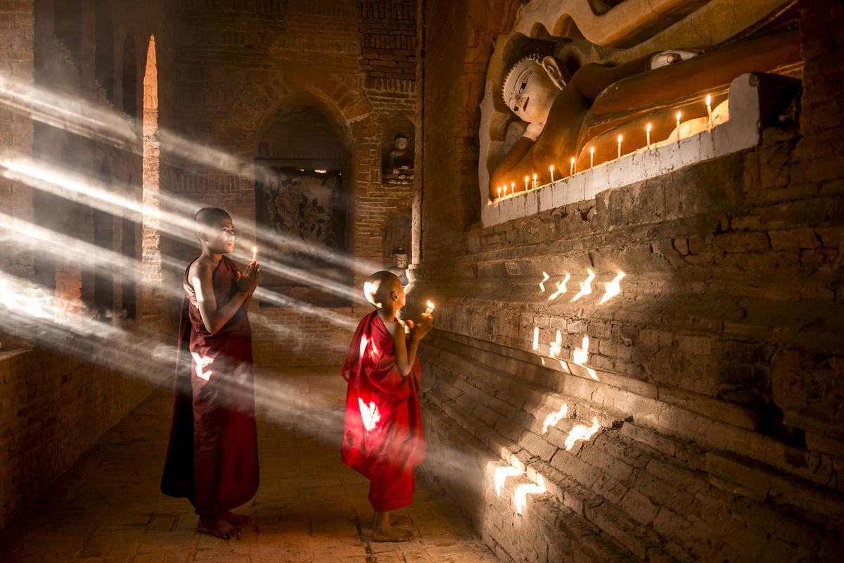 Two young Buddhist monks inside a temple in Bagan, Myanmar.