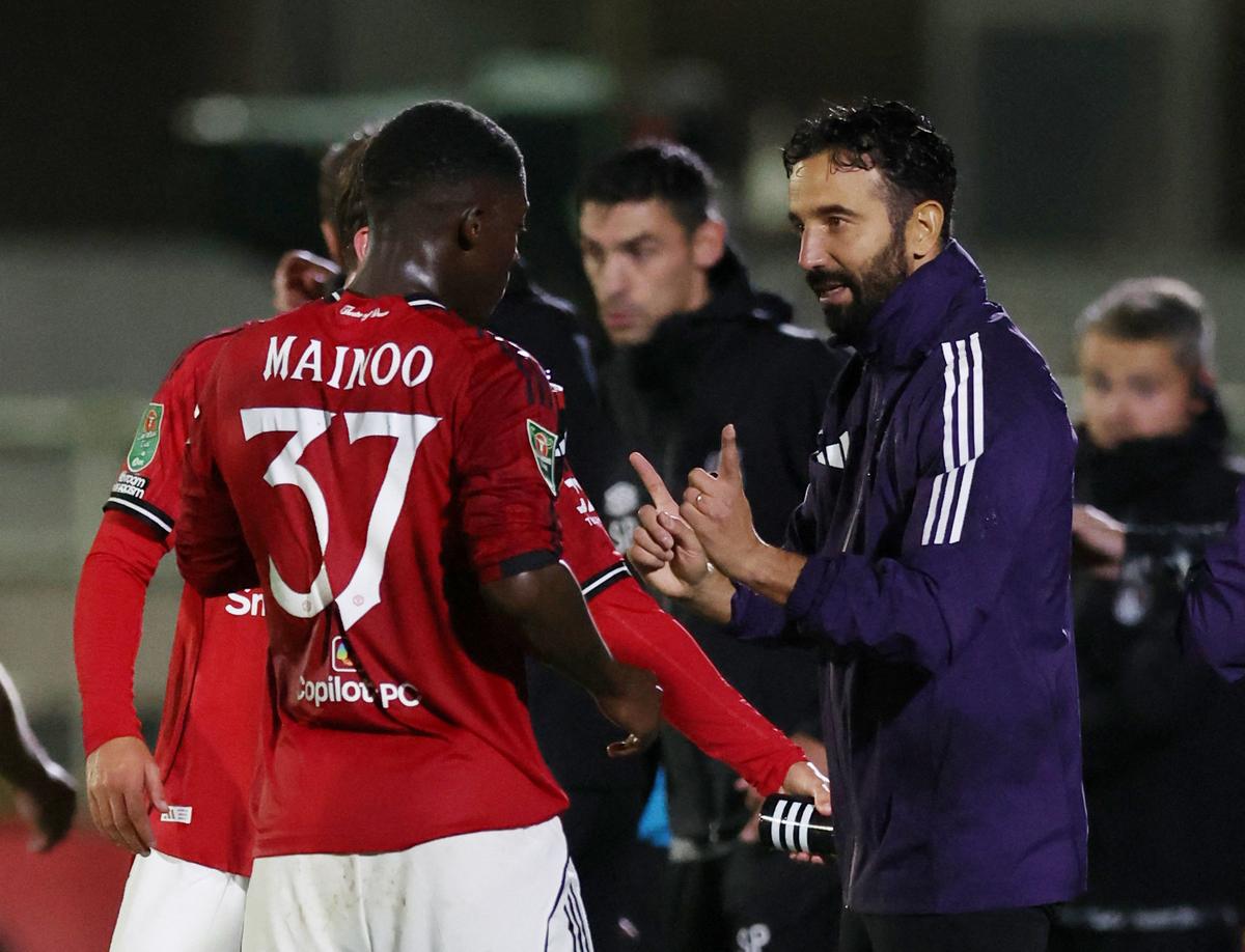 O gerente do Manchester United, Ruben Amorim, fala com Kobbie Manoo 