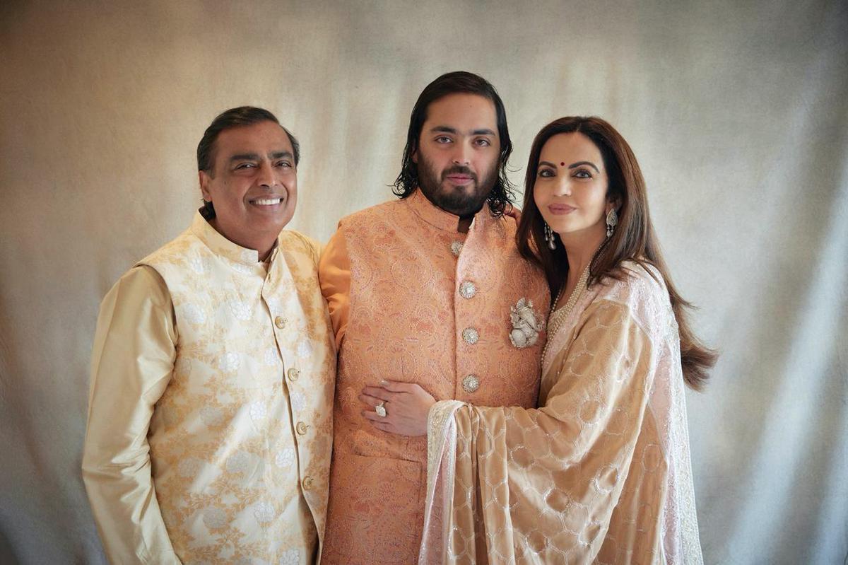 This photograph released by the Reliance group shows from L to R, billionaire industrialist Mukesh Ambani, son Anant and wife Nita, posing for a photograph as guests gather to celebrate Anant’s wedding in Jamnagar, India