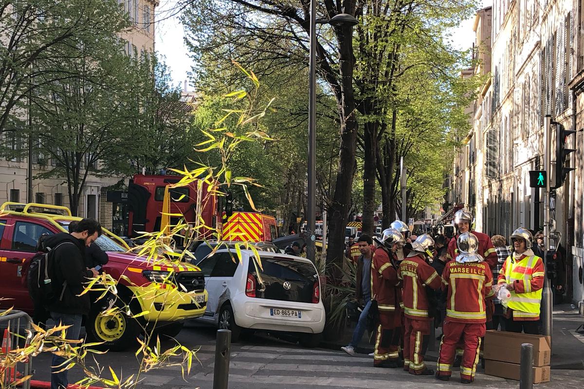 Firefighters gather near a street where a building collapsed in the early hours of Sunday, April 9, 2023, in Marseille, southern France.