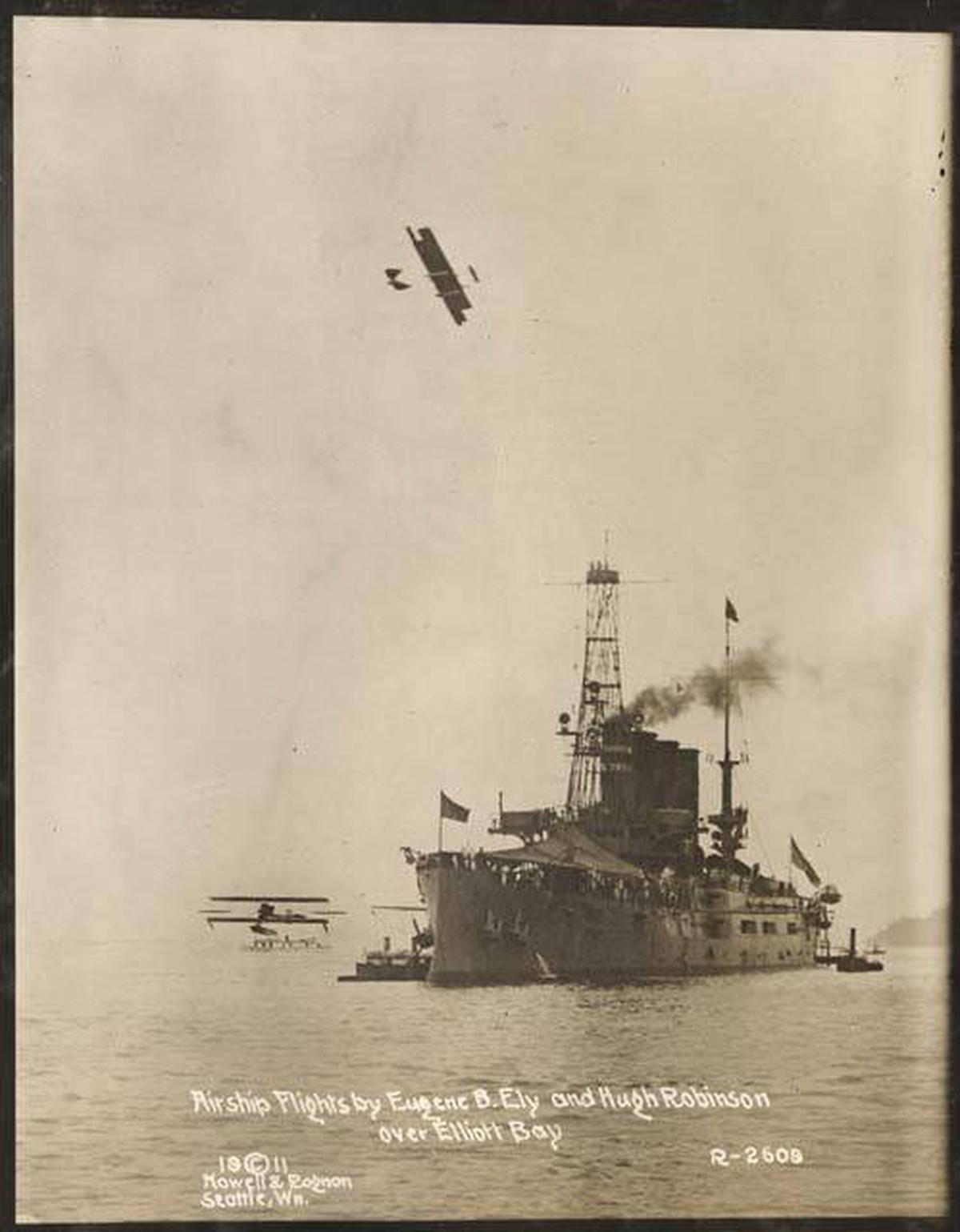 July 1911 picture showing a plane piloted by Ely flying over a naval ship.