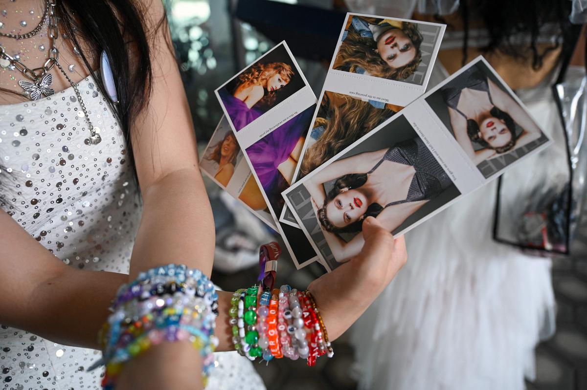 A fan of US singer Taylor Swift, also known as a Swiftie, wears friendship bracelets and holds postcards before the pop star’s Eras Tour concert at the National Stadium in Singapore on March 7, 2024