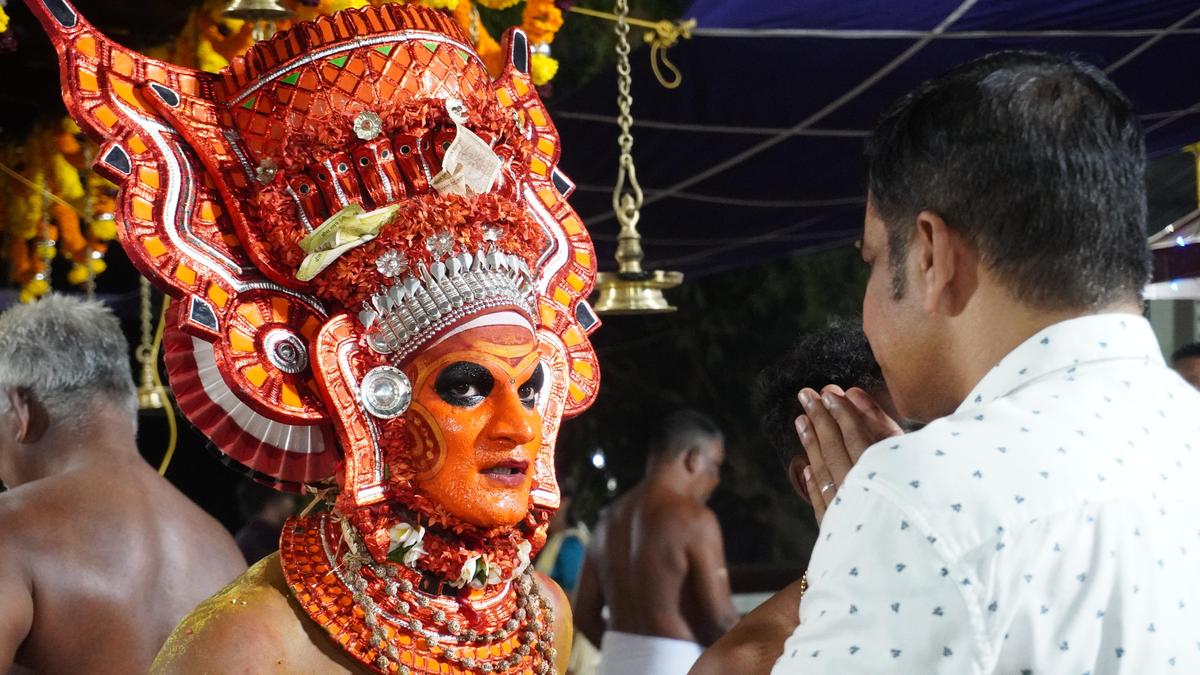 Gurukkal Theyyam blessing a devotee during Velattam