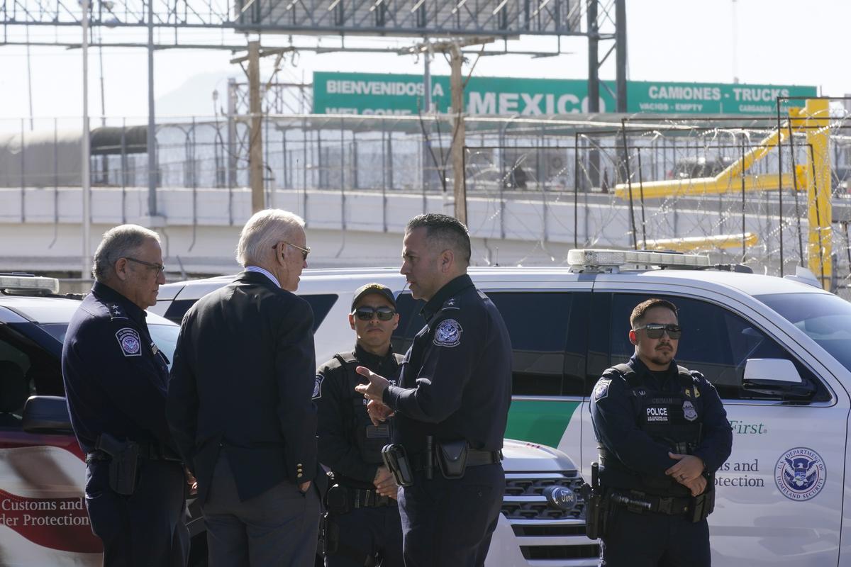 A large “Welcome to Mexico” sign hung over the Bridge of the Americas is visible as President Joe Biden, second from left, talks with U.S. Customs and Border Protection officers as he tours El Paso port of entry, Bridge of the Americas, a busy port of entry along the U.S.-Mexico border, in El Paso Texas.