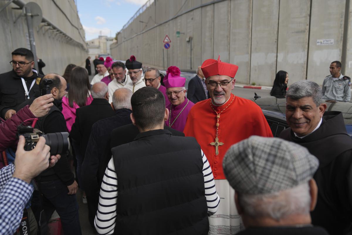 Archbishop Pierbattista Pizzaballa, the top Roman Catholic cleric in the Holy Land, is received by local community while crossing an Israeli military checkpoint from Jerusalem for Christmas Eve celebrations at the Church of the Nativity, traditionally recognized by Christians to be the birthplace of Jesus Christ, in the West Bank city of Bethlehem on December 24, 2024. 