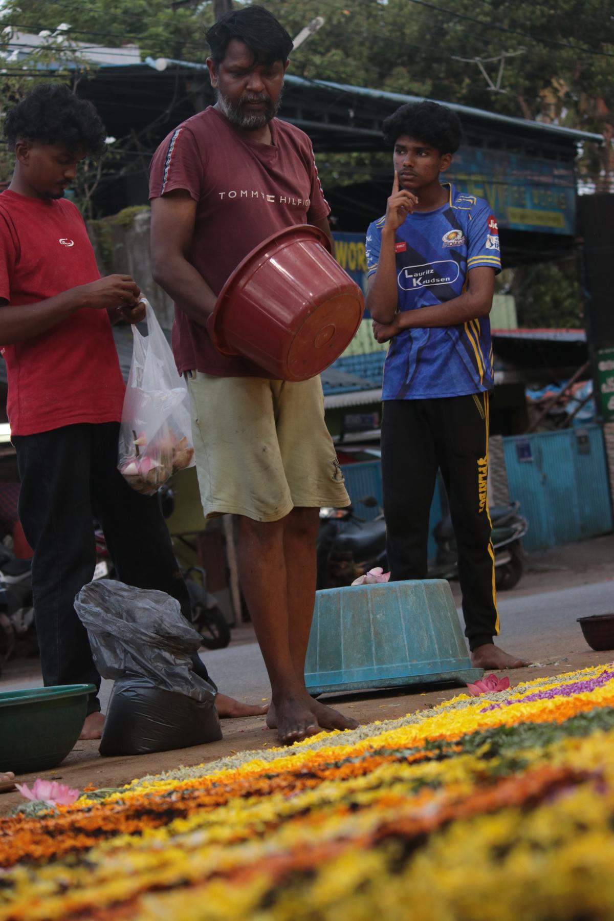 The artist working on the pookkalam at Poozhikkunnu in Thiruvananthapuram The artist working on the pookkalam at Poozhikkunnu in Thiruvananthapuram