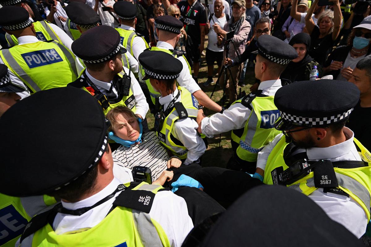 Police officers detain a demonstrator during a rally organised by Defend Our Juries, challenging the British government’s proscription of “Palestine Action” under anti-terrorism laws, in Parliament Square, in London on August 9, 2025.