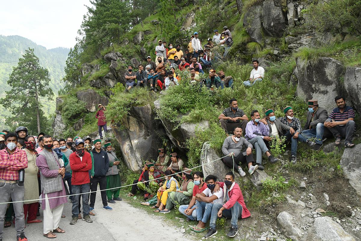 Tourists wait near the site of a landslide in Nigulsari, Himachal Pradesh, as rescue work gets underway, in 2018.
