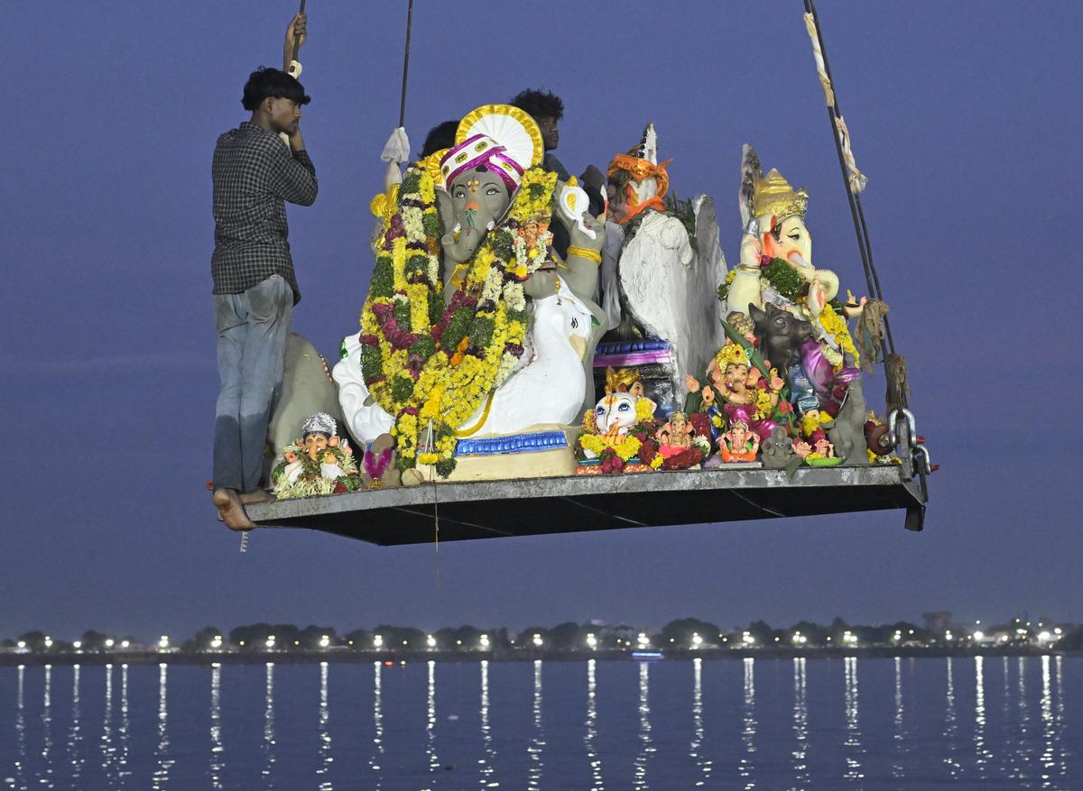 An idol being lowered into the  Hussainsagar for immersion on the fifth day of Ganesh Chaturthi celebrations in Hyderabad on Sunday.