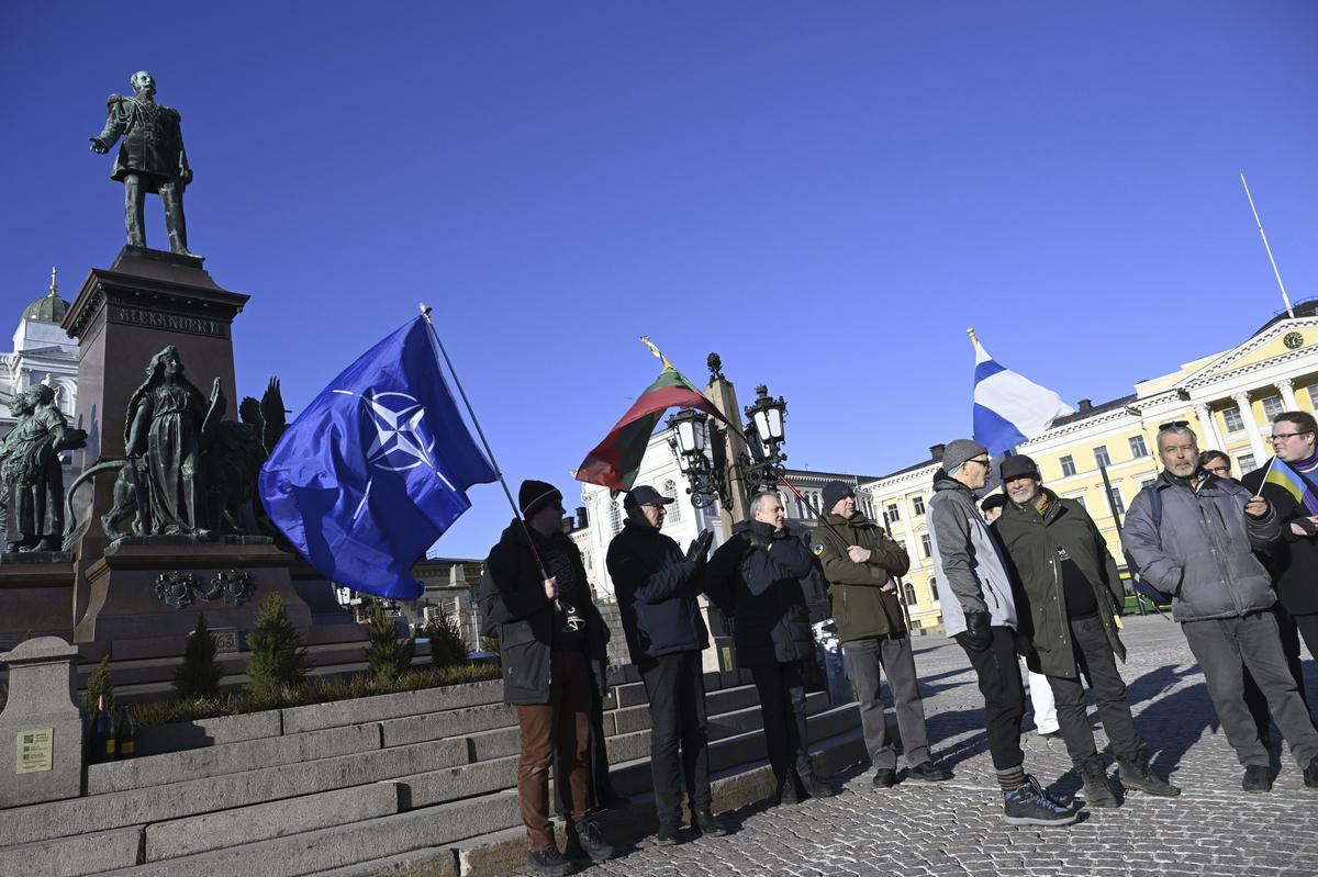 फ़िनलैंड के लोग, राष्ट्रीय और नाटो के झंडे के साथ, 4 अप्रैल, 2023 को फ़िनलैंड के हेलसिंकी में सीनेट स्क्वायर में फ़िनिश नाटो की सदस्यता का जश्न मनाते हैं। 