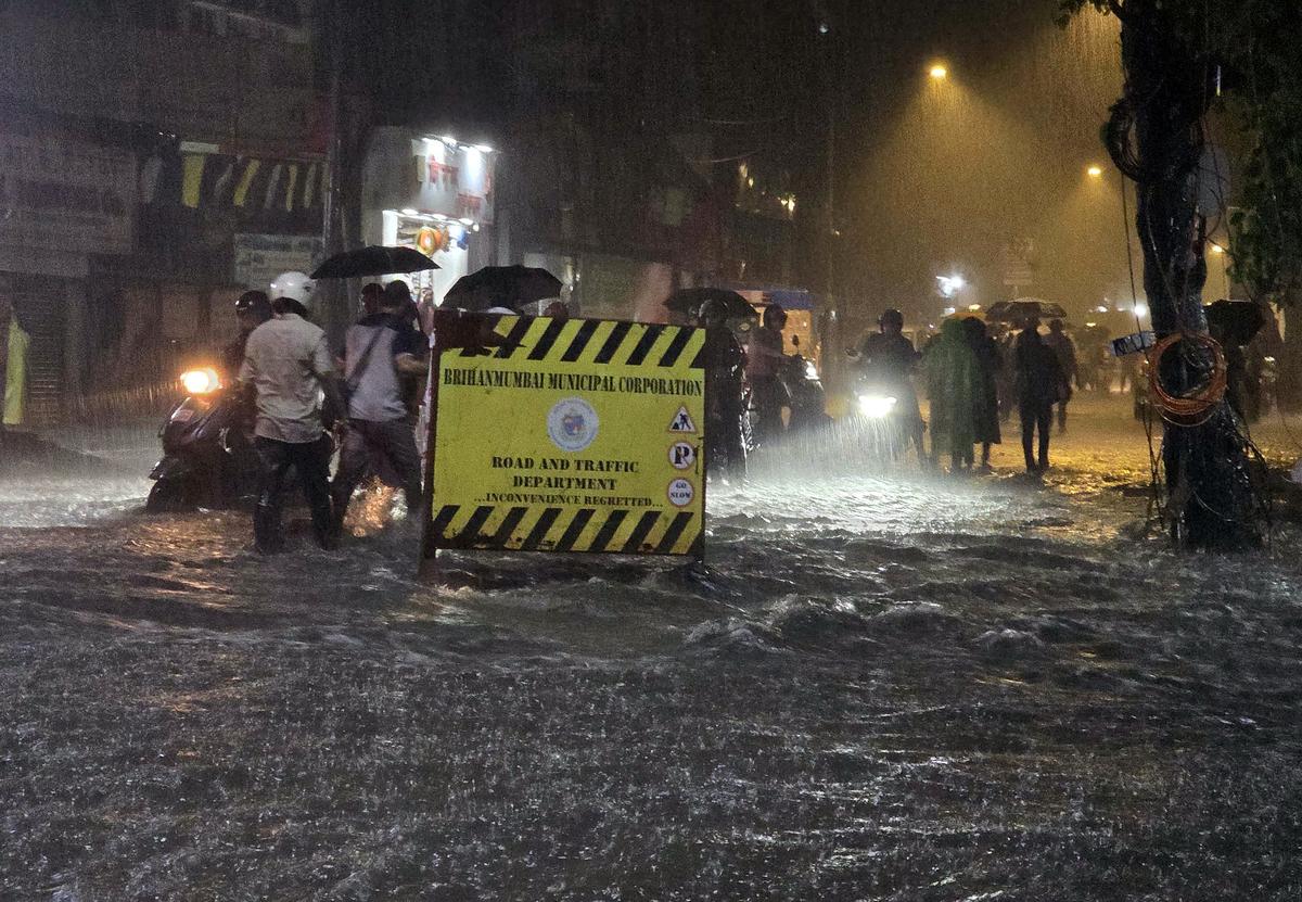 Commuters wade through a waterlogged road amid heavy rains as unseasonal rains lash several parts of Mumbai, at Andheri in Mumbai. Commuters wade through a waterlogged road amid heavy rains as unseasonal rains lash several parts of Mumbai, at Andheri in Mumbai.